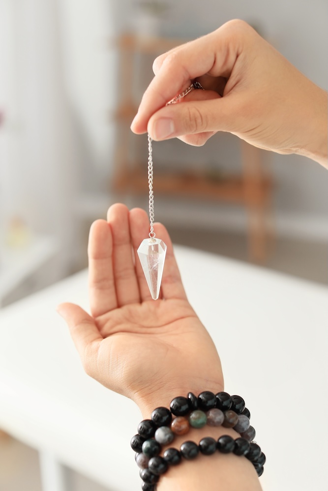 Reiki master with biolocation pendulum, closeup