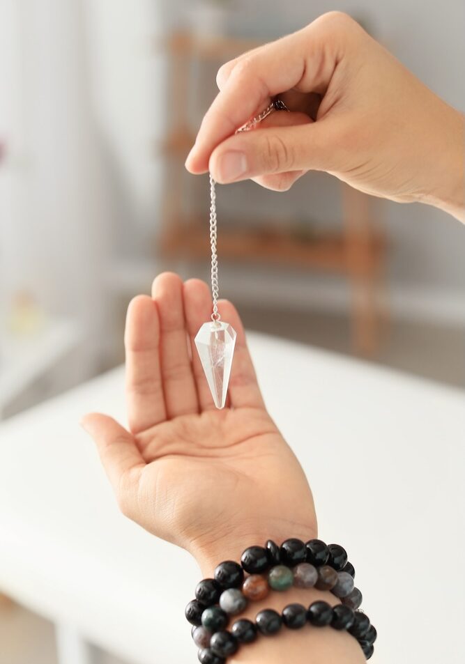 Reiki master with biolocation pendulum, closeup
